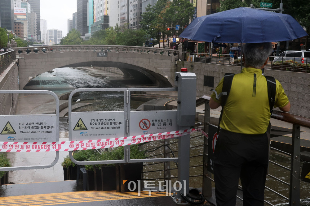 ▲중부지방을 중심으로 강한 장맛비가 내리는 14일 서울 청계광장에서 우산을 쓴 시민이 통제된 청계천을 바라보고 있다. 기상청에 따르면 비는 오후부터 소강상태를 보였다가 15일 오전부터 수도권과 강원 내륙 지역에서는 다시 내릴 것으로 보인다. 고이란 기자 photoeran@