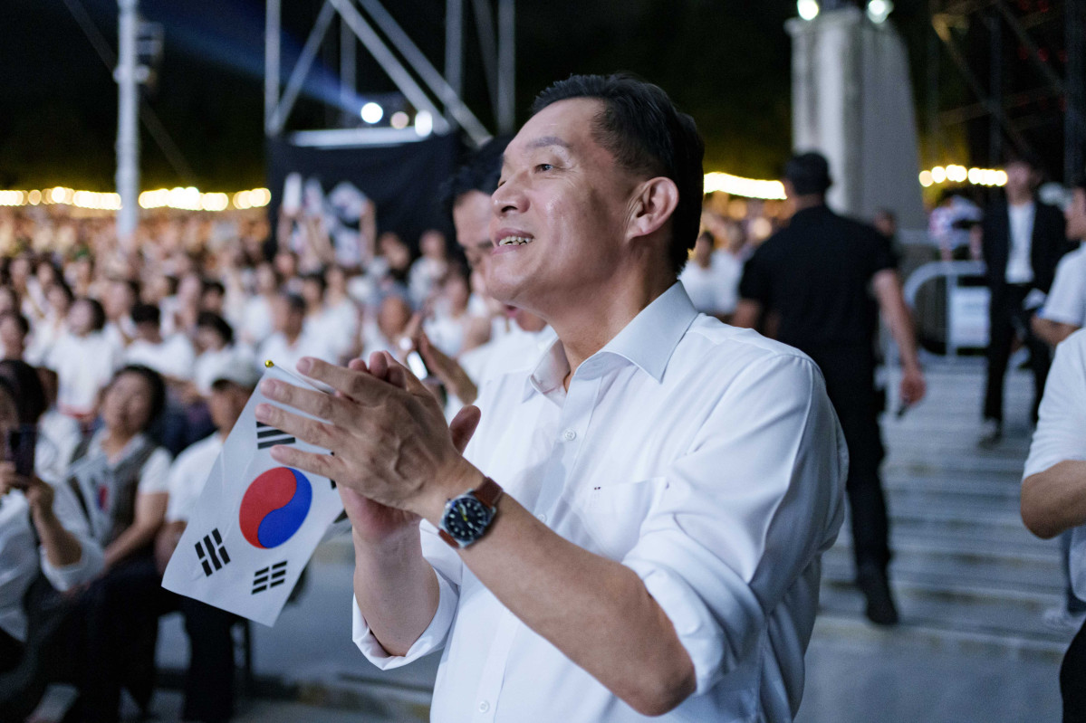 ▲이재준 수원시장이 15일 수원제1야외음악당에서 열린 광복 80주년 기념 대합창에 참석해 태극기를 들고 박수를 치고 있다. (수원특례시)