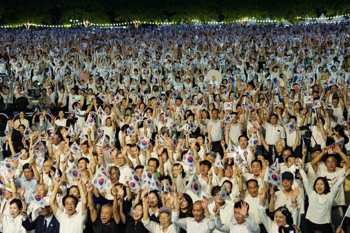 ▲수원제1야외음악당에서 시민들이 한국 국기를 들고 광복 80주년 기념 대합창 행사에 참여하고 있다. (수원특례시)