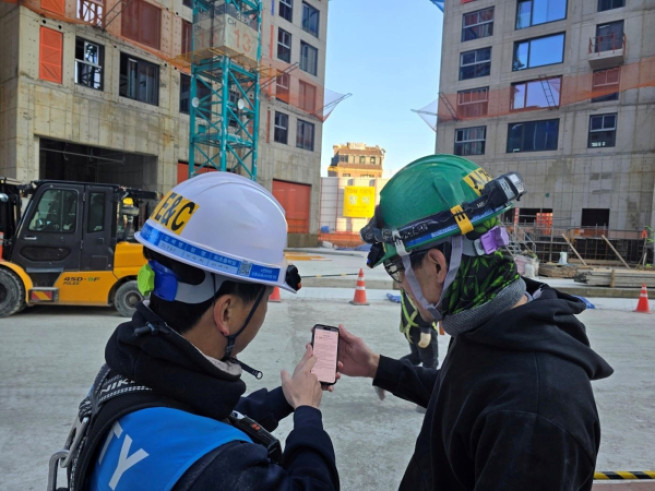 ▲DL이앤씨 직원이 수도권의 한 아파트 건설 현장에서 외국인 노동자에게 ‘AI 자동번역 시스템’을 안내하고 있다. (사진제공=DL이앤씨)