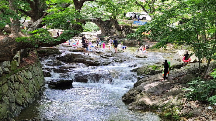 ▲전남 순천 주암면 용오름 마을의 맑은 계곡에서 방문객들이 나무숲과 어우러진 자연 속에서 물놀이와 휴식을 즐기고 있다. (사진제공=전남도)