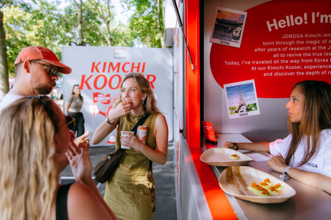 ▲대상 김치 브랜드 종가가 런던 대표 뮤직 페스티벌 ‘APE 2025’에서 운영한 부스 '테이스팅존'에서 외국인 방문객이 김치 요리를 맛보고 있다. (사진제공=대상)