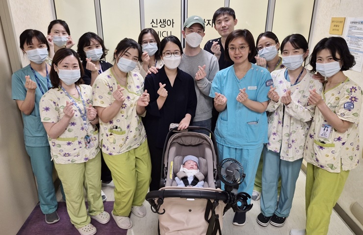 ▲서울성모병원에서 22주 3일만에 태어나 건강하게 귀가하는 이른둥이 가족이 퇴원을 기념해 의료진과 사진을 촬영하고 있다. (서울성모병원)