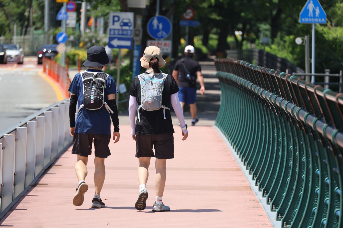▲대전 한낮 기온이 30도에 육박하며 더운 날씨를 보인 10일 대전 대덕구 대청댐 산책로를 찾은 시민들이 걸으며 한여름의 정취를 즐기고 있다.  (사진=연합뉴스)