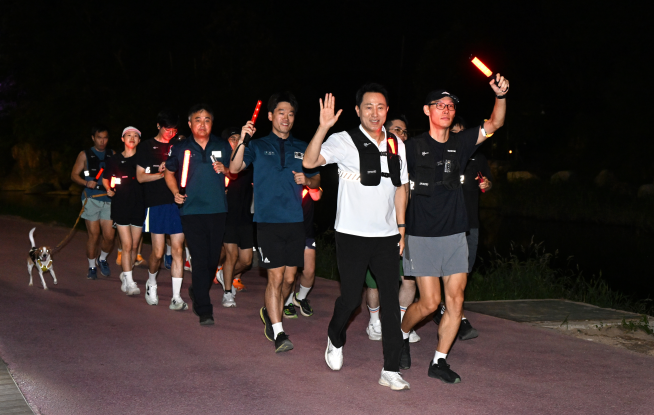 ▲오세훈 서울시장이 21일 ‘서울 러닝 순찰대’와 홍제천 일대 순찰 중 시민에게 손을 흔들며 인사하고 있다. (사진제공=서울시)