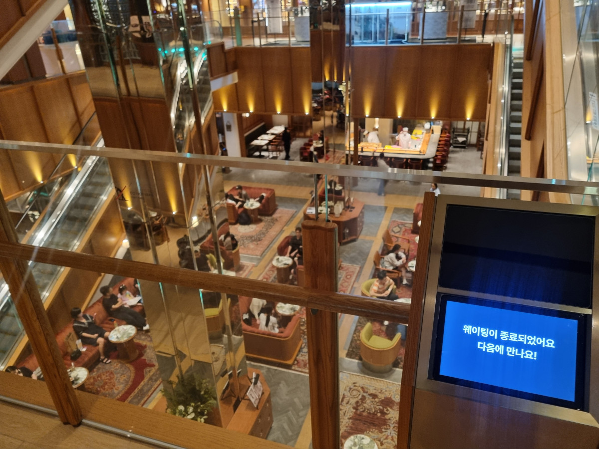 ▲8월 19일 오후 8시55분께 ‘하우스오브신세계’ 1층에서 내려다 본 전경. 해당 층 식당의 웨이팅이 종료된 시간이었지만, 지하1층 푸드홀 대기 공간에는 사람들이 빼곡했다. 몇몇은 자리가 없어 기둥에 기대 서서 아이스크림을 먹기도 했다.  (유하영 기자 haha@)