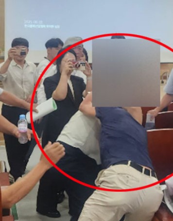 ▲공청회장에서 순천시의회 공무원이 이장을 이른바 헤드락하고 있다. (사진제공=독자)