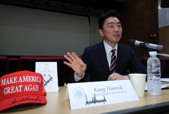 ▲강훈식 비서실장이 28일 용산 대통령실에서 기자간담회 중 트럼프 대통령에게 본인이 받은 선물에 대해 설명하고 있다. 그 앞에 트럼프 대통령의 사인이 있는 마가 모자, 오찬 메뉴판, 비서실장 명패 등이 놓여 있다. (연합뉴스)