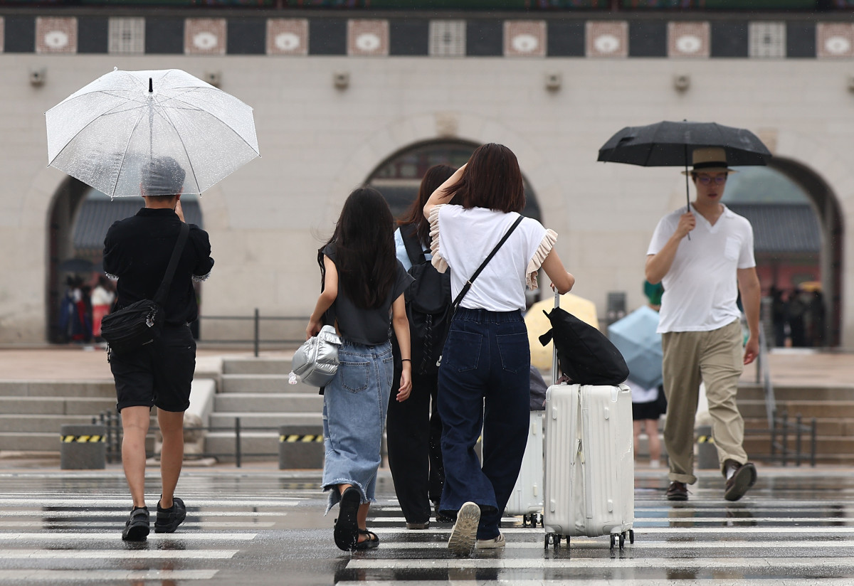 ▲소나기가 내린 25일 오전 서울 종로구 광화문 인근에서 외국인 관광객이 비를 피하고 있다. (사진제공=연합뉴스)