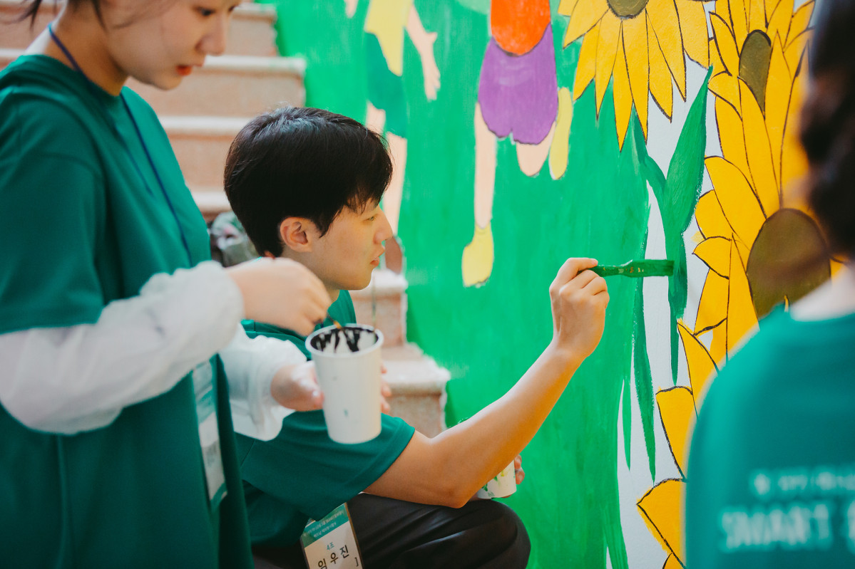 ▲하나금융 스마트 홍보대사들이 이달 중순 베트남 하노이 뜨 끄엉(Tu Cuong) 초등학교에서 벽화 그리기 봉사활동을 하고 있다. (사진제공=하나금융)