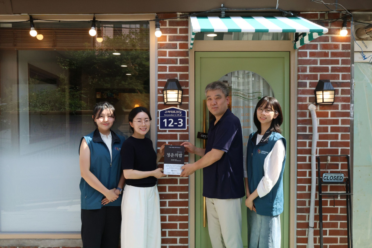 ▲서울 성북구 '히포크라테스 스프'에서 열린 '청춘의 밥' 프로젝트 50호점 현판식에서 김경숙(왼쪽부터 두번째) 대상주식회사 ESG경영실장과 김혁(왼쪽부터 세번째) 히포크라테스 스프 대표가 대상 대학생봉사단원들과 기념사진을 촬영하고 있다. (사진제공=대상그룹)