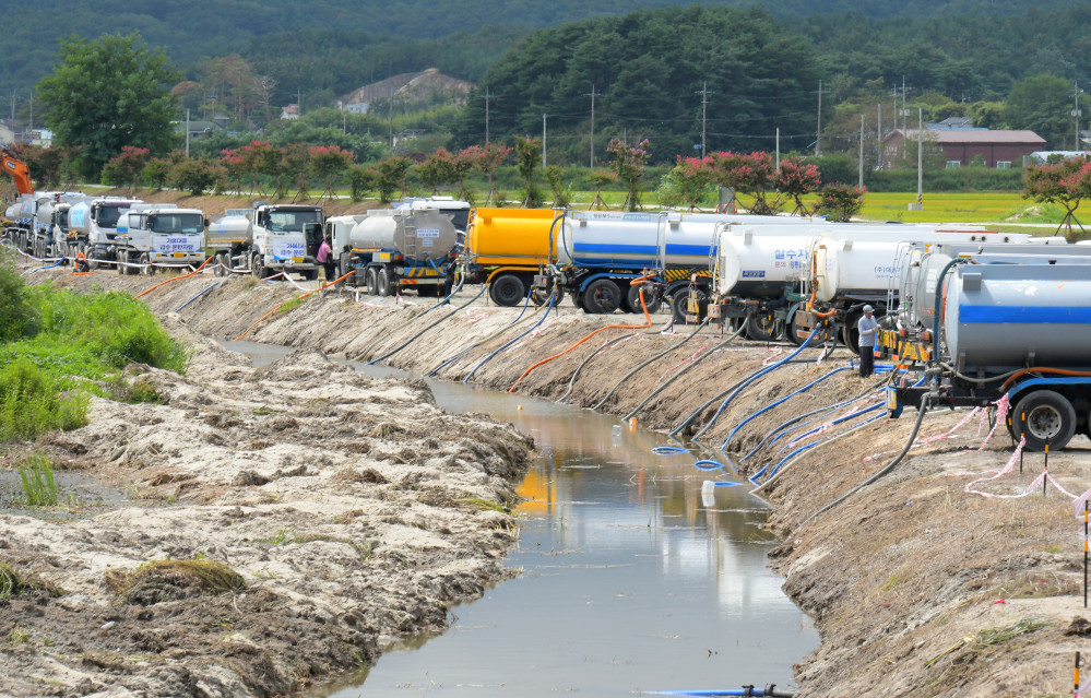 ▲2일 강원 강릉시 외곽의 한 하천에서 전국에서 지원하러 온 살수차들이 강릉시 상수원인 오봉저수지에 투입할 물을 담고 있다. (연합뉴스)