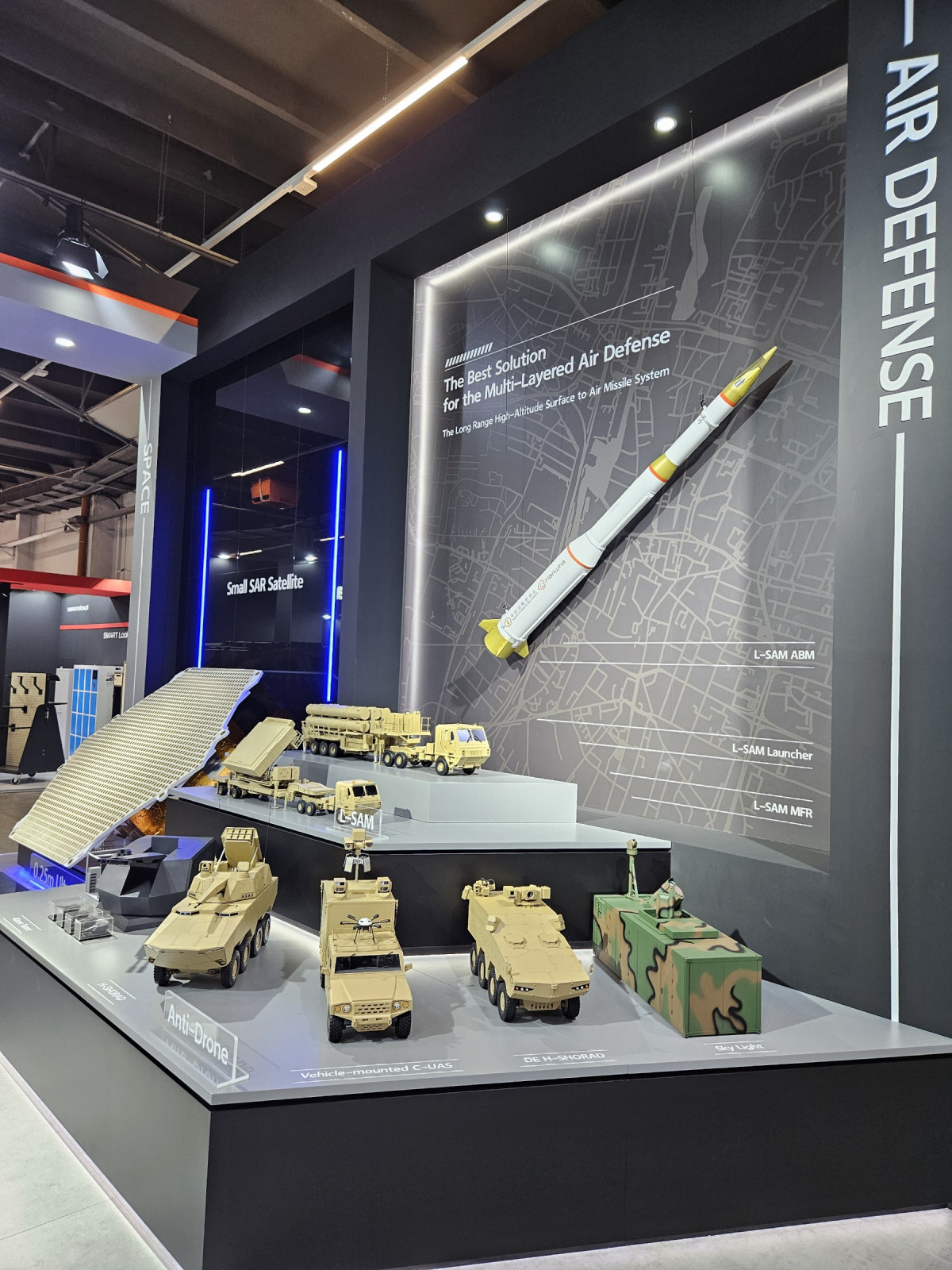 ▲한화시스템의 레이저 대공무기 ‘천광’(사진 맨앞 맨오른쪽)이 폴란드 키엘체에서 열린 MSPO 2025에 전시돼 있다. 아랫단 왼쪽부터 한화에어로의 40mm 지능형 무인방공시스템과 H-쇼라드, 한화시스템의 기동형 안티드론 솔루션, DE H-쇼라드, 천광. (한화시스템)