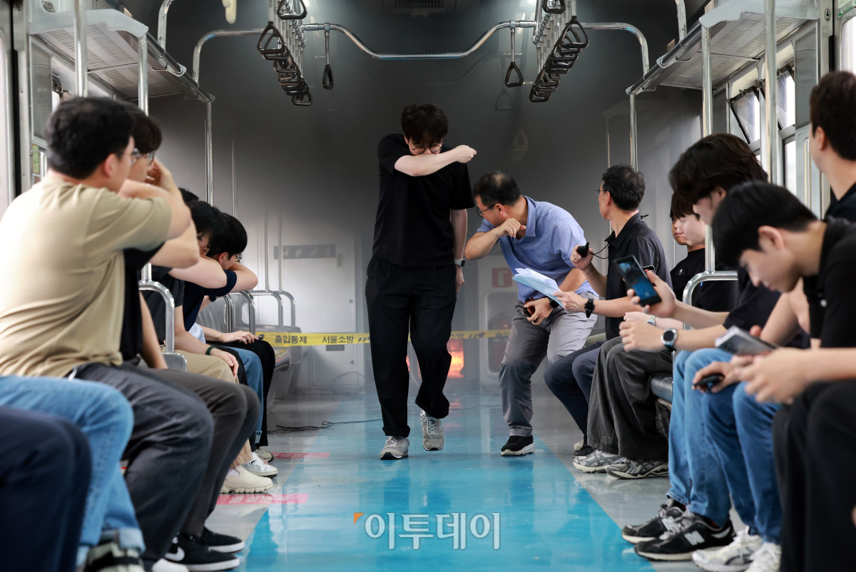 ▲4일 경기 고양시 지축차량기지에서 열린 5호선 열차 방화관련 화재안정성 및 비상대응 검증을 위한 전동차 화재안전 시연회에서 불이 난 전동차 객실에서 승객을 가정한 서울교통공사 직원들이 대피하고 있다. 조현호 기자 hyunho@