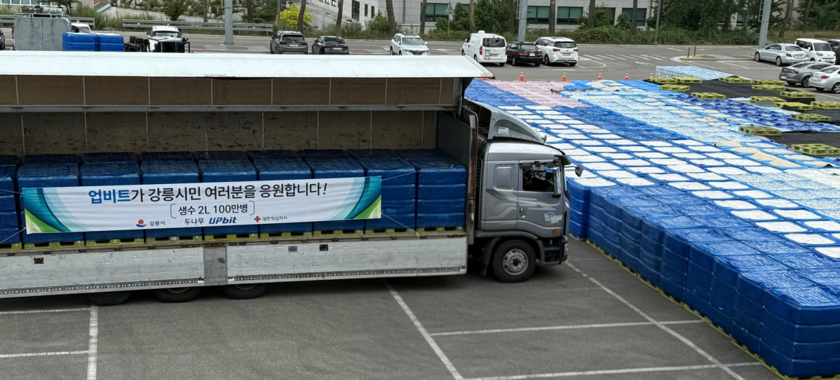 ▲업비트가 강릉시 가뭄 위기 극복을 위해 기부한 생수 100만 병이 강릉올림픽파크아레나경기장에 내려지고 있다. (사진=두나무)