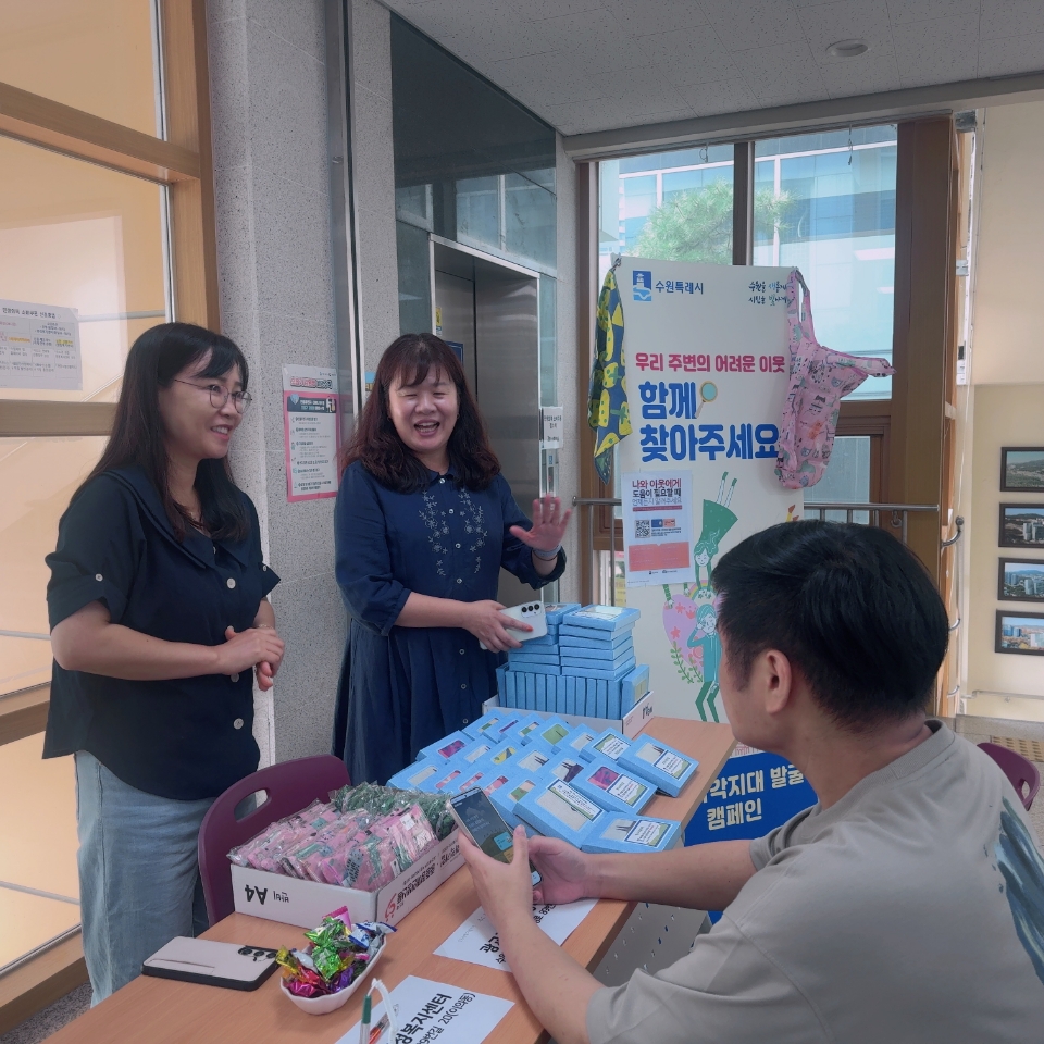 ▲광교1동 송숙영 동장과 직원들이 테이블에 모여 복지사각지대 해소 캠페인을 진행하고 있다. (수원시 영통구 광교1동)