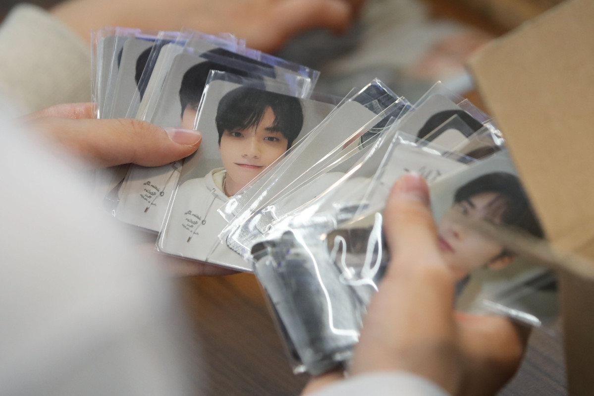 ▲2023년 10월 13일 오후 서울 마포구 CU 에이케이&홍대점에서 '투모로우바이투게더' 정규 3집 앨범을 구매한 시민이 포토카드를 정리하고 있다. (뉴시스)