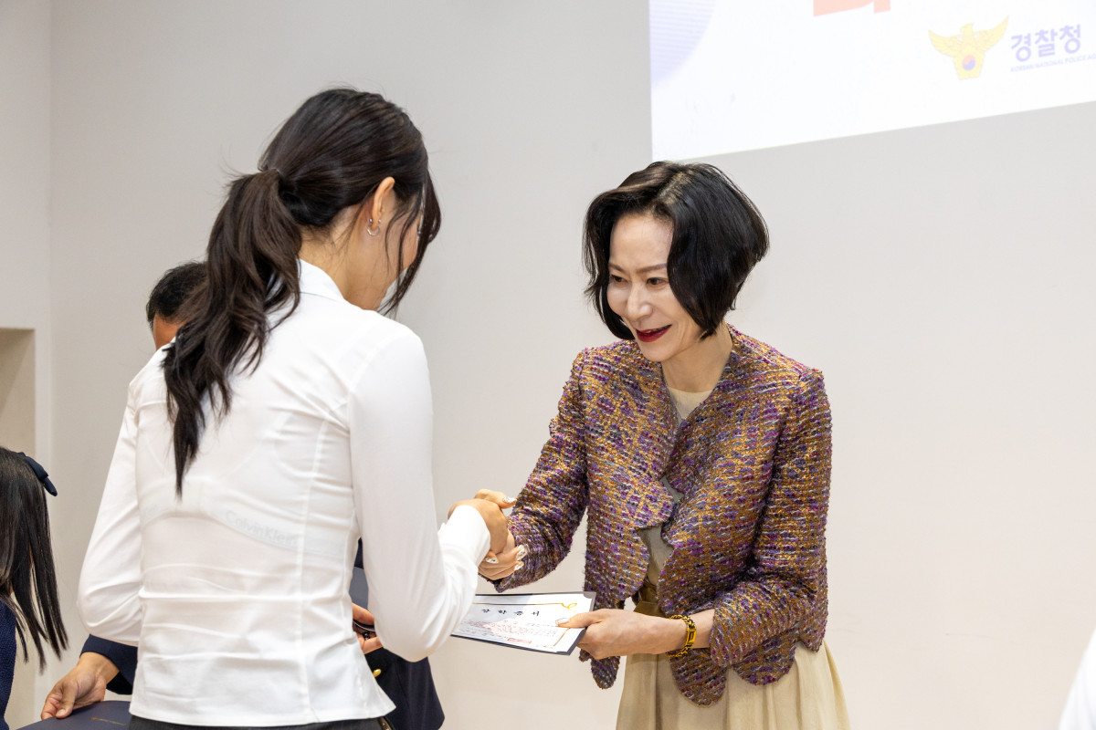 ▲장혜선 롯데장학재단 이사장이 장학생에게 장학증서를 수여하며 인사를 나누고 있다. (사진제공=롯데장학재단)