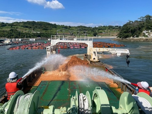 ▲전남 여수 해안에서 황토를  살포하고 있다. (사진제공=여수시)