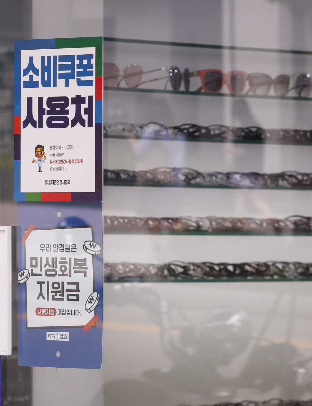 ▲민생회복 소비쿠폰이 소상공인 매출에 효과가 있는 것으로 나타났다. 4일 한국신용데이터(KCD)에 따르면 민생회복 소비쿠폰 배포가 시작된 한 주(7월 21일∼27일) 동안 전국 소상공인 평균 카드 매출액은 전 주 대비 2.2% 늘었다. 업종별로 보면 안경원 매출이 전 주 대비 56.8% 치솟으며 증가율이 가장 높았고, 패션·의류업 매출도 28.4% 늘었고, 면 요리 전문점(25.5%), 피자(23.7%), 초밥·롤 전문점(22.4%), 미용업(21.2%), 스포츠·레저용품(19.9%) 등도 매출액 증가 폭이 컸다. 이날 서울 시내 한 안경점에 민생회복 소비쿠폰 안내문이 붙어 있다. 조현호 기자 hyunho@(이투데이DB)