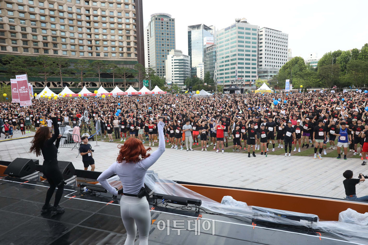 ▲14일 오전 서울광장에서 열린 ‘마블런 서울 2025’ 행사에서 행사 참가자들이 함께 어울려 준비 운동을 하며 도심 축제를 즐기고 있다. 행사 시작 전, 마블런 참가자들은 DJ 카주쇼타임의 디제잉 퍼포먼스로 한층 고조된 축제 분위기를 즐기며 몸풀기 스트레칭을 진행했다. 사진제공=디즈니