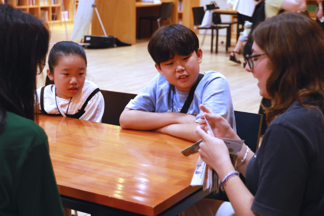 ▲7월 19일 경기도 파주 '지혜의 숲'에서 진행된 '영어 동화작가 되기 원데이클래스'에서 체험단 참가자들이 원어민 선생님이 진행하는 스토리텔링 수업을 듣고 있다. (사진제공=웅진그룹)