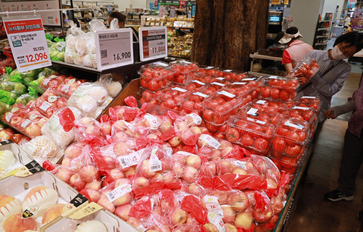 ▲ 슈퍼마켓 과일 코너에서 고객들이 사과와 토마토 등 신선 식품의 가격표를 확인하고 있다. (출처=연합뉴스)