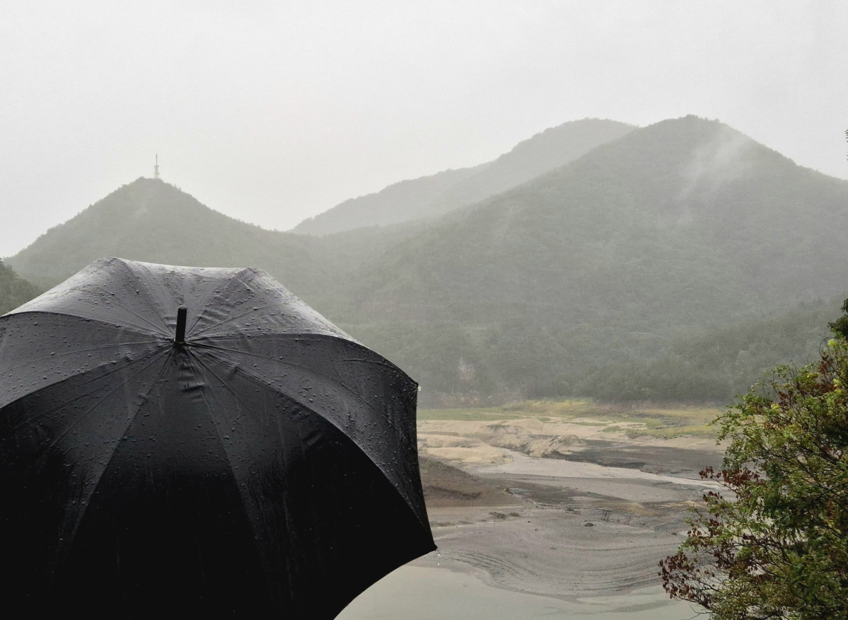 ▲13일 가뭄으로 메마른 강원 강릉시 오봉저수지 일원에 비가 내리자 시민들이 우산을 쓰고 바라보고 있다. (연합뉴스)