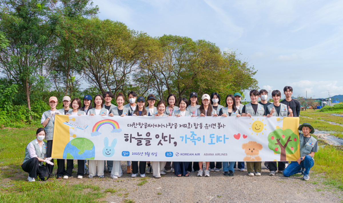 ▲유기견 봉사활동에 참여한 대한항공과 아시아나항공 임직원들이 기념촬영을 하는 모습. (사진=대한항공)