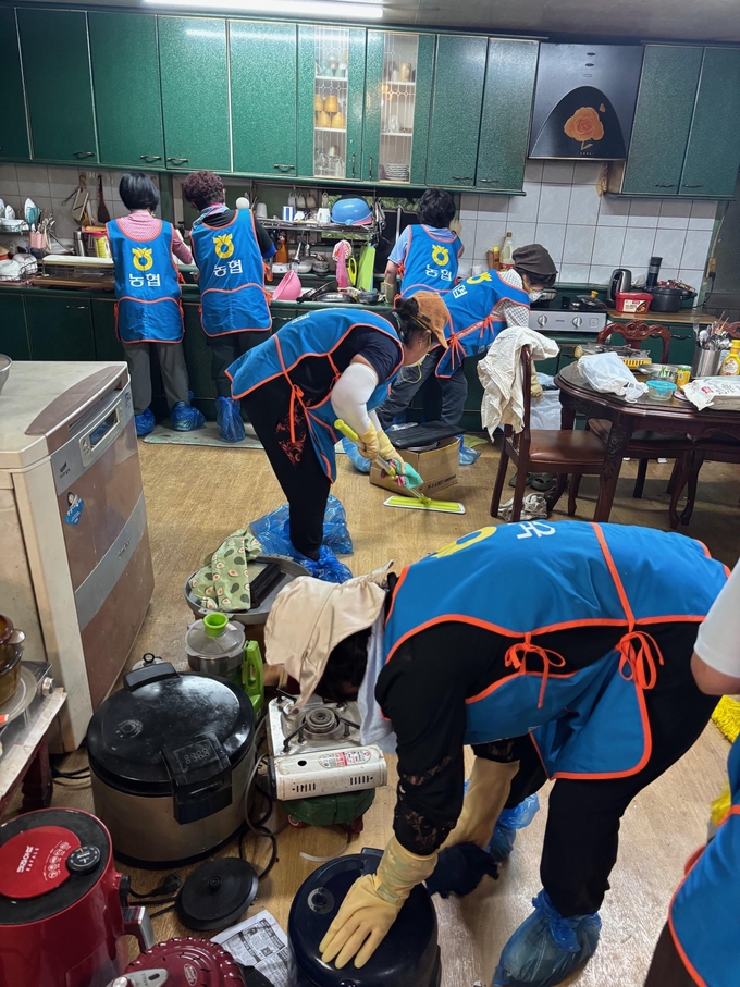 ▲농가주부모임경기도연합회 클린봉사단원이 포천시 관인면 수해 피해 주택의 주방에서 청소 봉사활동을 하고 있다. (경기농협)