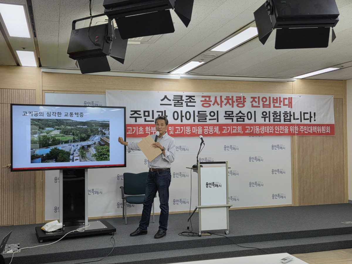 ▲고기초등학교 학부모회와 고기동 주민 비상대책위원회 관계자가 스크린 앞에서 스쿨존 내 공사차량 진입 반대를 주제로 교통 체증과 안전 문제를 발표하고 있다. (용인특례시 고기초 학부모회·대책위)