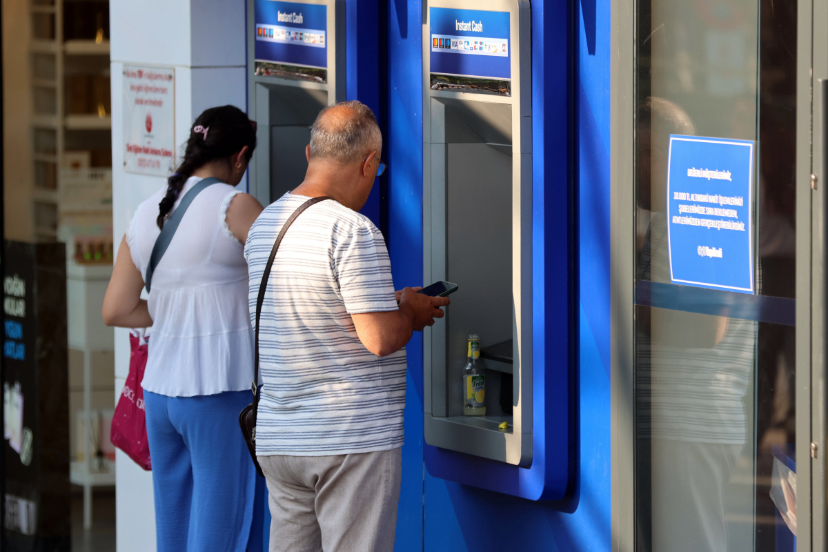 ▲튀르키예 앙카라에서 3일(현지시간) 사람들이 ATM으로 현금을 찾고 있다.  (앙카라/신화뉴시스)