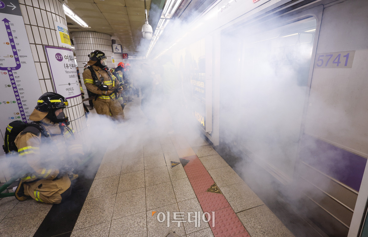 ▲22일 서울 영등포구 여의나루역 일대에서 열린 2025년 서울시 재난대응 안전한국훈련에서 소방대원들이 화재 진압 훈련을 하고 있다. 재난대응 안전한국훈련은 지하 47m(아파트 16층 높이)에 위치해 지상으로 이동 동선이 긴 5호선 여의나루역에서 휴대용 배터리 발화 및 고의적 방화로 화재가 발생, 대피 중 인파 사고와 흉기 난동 등이 복합적으로 발생하는 상황을 가정해 이뤄졌다. 조현호 기자 hyunho@