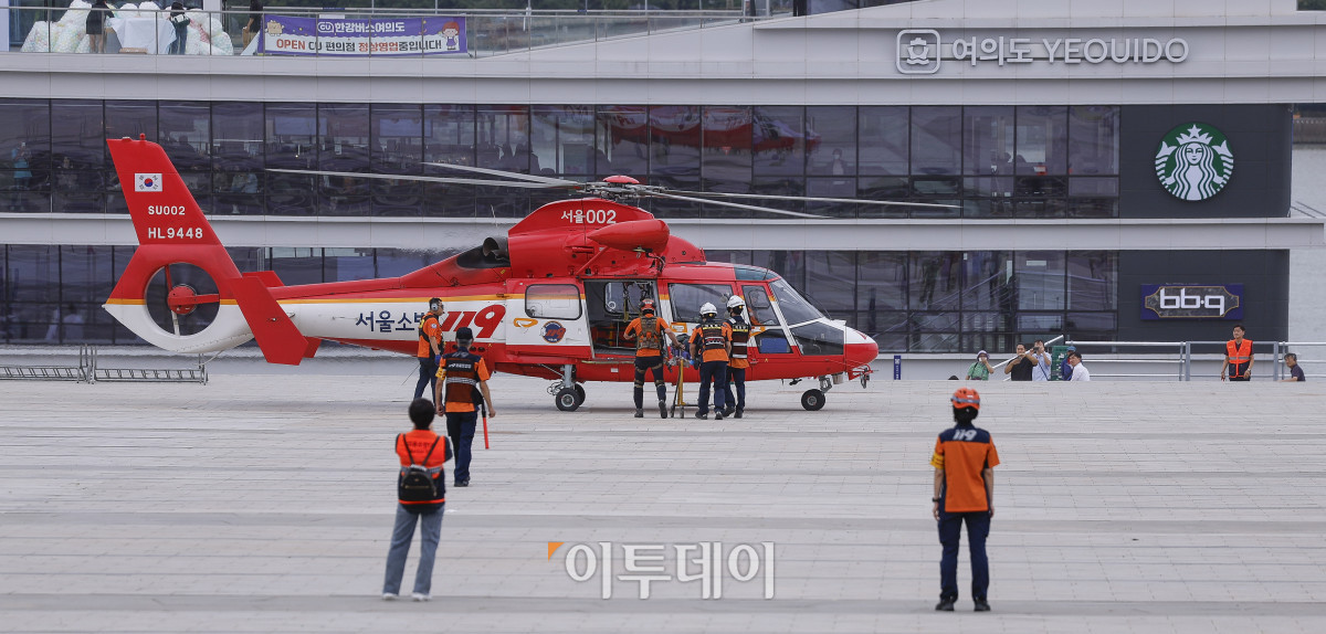 ▲22일 서울 영등포구 여의나루역 일대에서 열린 2025년 서울시 재난대응 안전한국훈련에서 소방헬기가 부상자를 이송하고 있다. 재난대응 안전한국훈련은 지하 47m(아파트 16층 높이)에 위치해 지상으로 이동 동선이 긴 5호선 여의나루역에서 휴대용 배터리 발화 및 고의적 방화로 화재가 발생, 대피 중 인파 사고와 흉기 난동 등이 복합적으로 발생하는 상황을 가정해 이뤄졌다. 조현호 기자 hyunho@