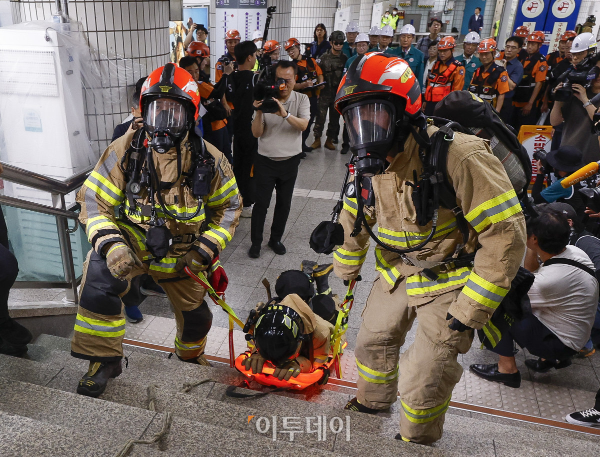 ▲22일 서울 영등포구 여의나루역 일대에서 열린 2025년 서울시 재난대응 안전한국훈련에서 소방대원들이 대피 훈련을 하고 있다. 재난대응 안전한국훈련은 지하 47m(아파트 16층 높이)에 위치해 지상으로 이동 동선이 긴 5호선 여의나루역에서 휴대용 배터리 발화 및 고의적 방화로 화재가 발생, 대피 중 인파 사고와 흉기 난동 등이 복합적으로 발생하는 상황을 가정해 이뤄졌다. 조현호 기자 hyunho@
