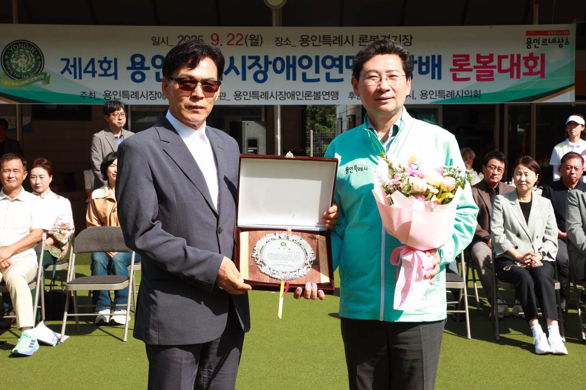 ▲이상일 용인특례시장이 용인시론볼경기장에서 열린 제4회 용인시 장애인연맹회장배 론볼대회 시상식에서 감사패와 꽃다발을 받고 있다. (김재학 기자)