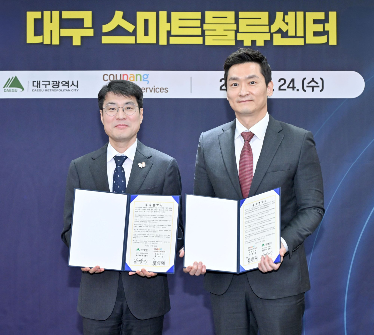 ▲김정기 대구광역시장 권한대행(좌측)과 곽형주 쿠팡로지스틱스서비스 상무가 24일 오후 대구광역시청에서 열린 '쿠팡로지스틱스서비스 대구 스마트물류센터 신설 투자협약식'에서 협약서를 들고 기념 촬영을 하고 있다 (사진제공=쿠팡)