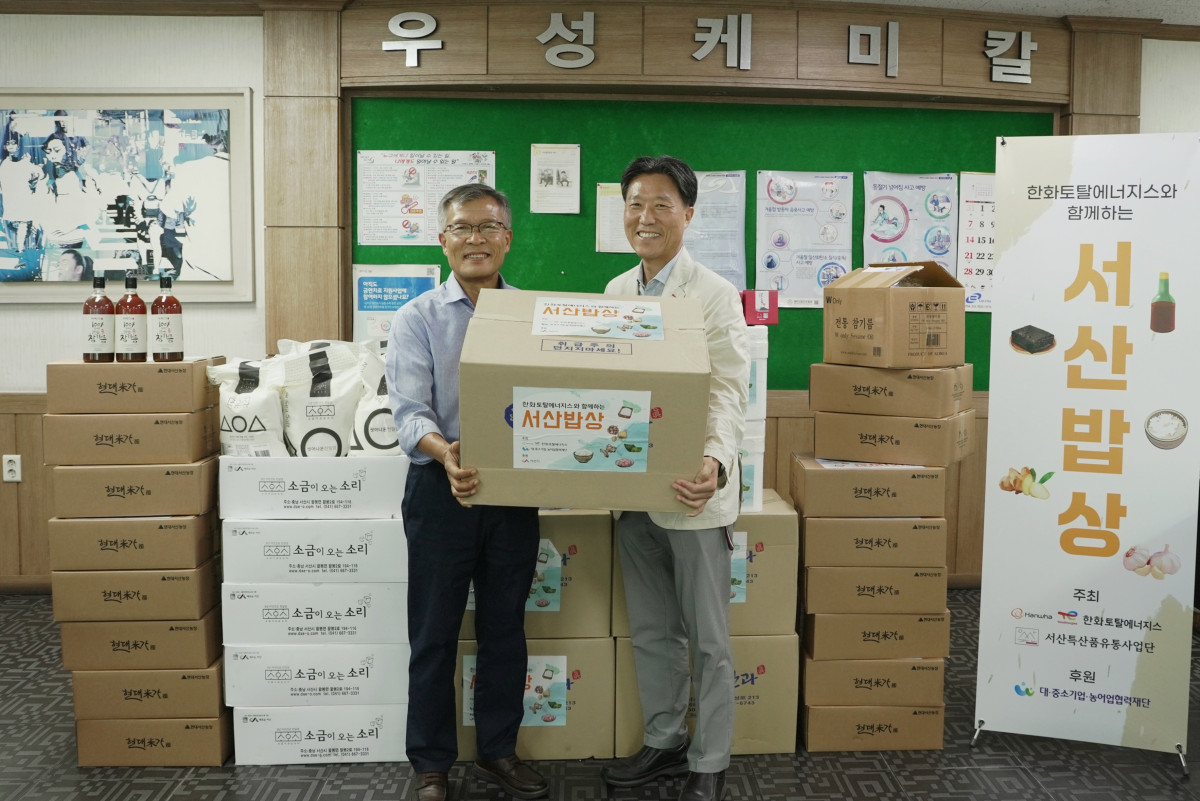 ▲25일 한화토탈에너지스 관계자(오른쪽)가 고객사 박병욱 우성케미칼 대표이사(왼쪽)에게 농수산물을 전달하고 있다. (사진= 한화토탈에너지스)