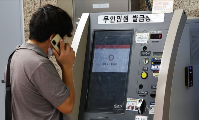 ▲27일 서울 시내 한 지하철역에 설치된 무인민원발급기에서 한 시민이 서류가 발급되지 않자 통화를 하고 있다. (연합뉴스)