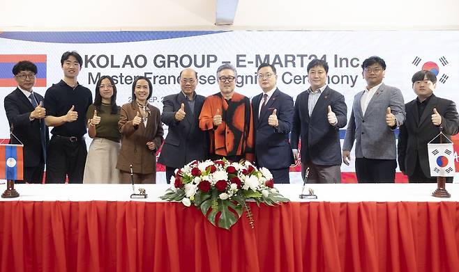 ▲이마트24가 지난 25일 라오스 비엔티안 코라오그룹 본사에서 이마트24 강인석 상무(오른쪽에서 네번째), 코라오그룹 오세영 회장(오른쪽에서 다섯번째)이 라오스 진출을 위한 마스터 프랜차이즈 계약을 체결 후 기념 촬영을 하고 있다. (사진제공=이마트24)