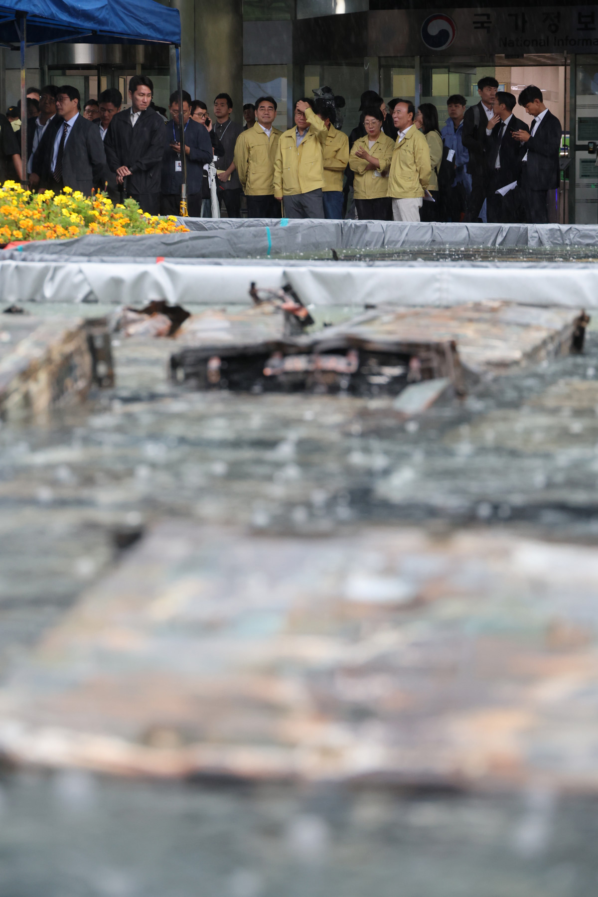 ▲28일 국회 행정안전위 위원들이 화재가 발생한 대전 유성구 국가정보자원관리원을 찾아 외부 침수조에 냉각작업 중인 리튬이온 배터리를 살펴보고 있다. (사진=뉴시스)