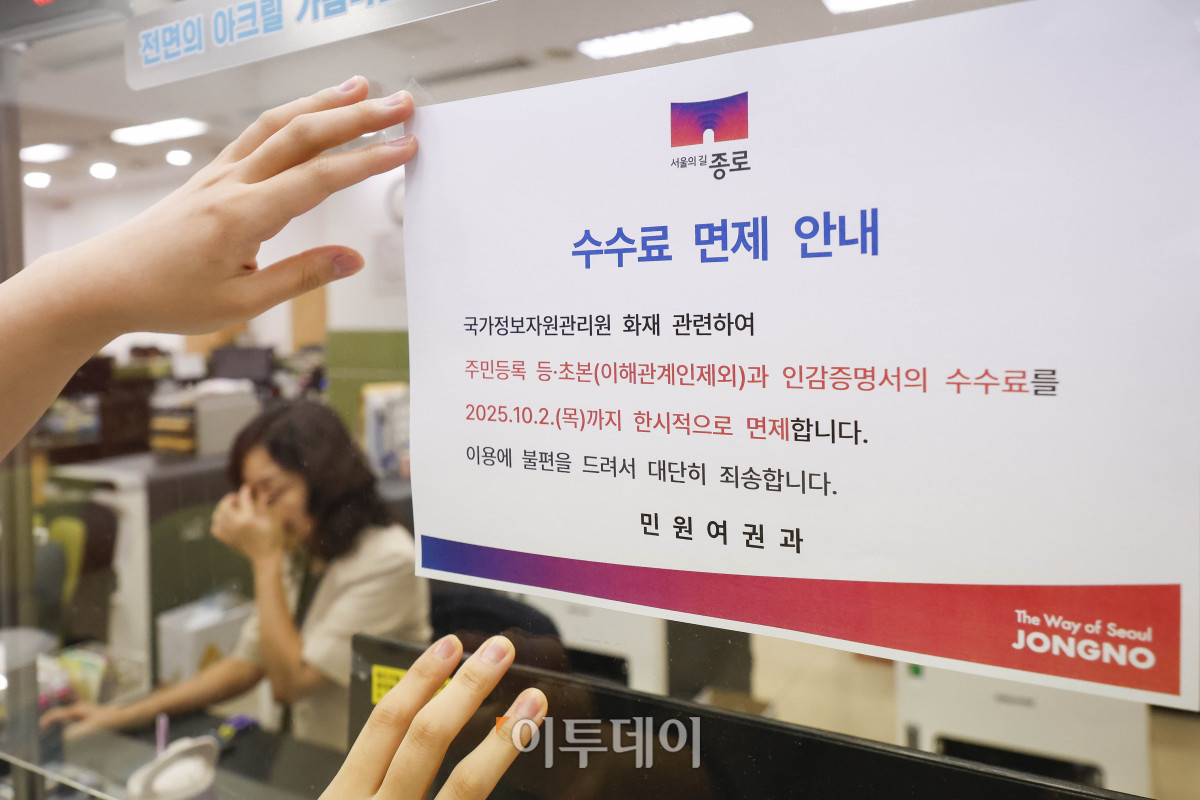 ▲국가정보자원관리원(국정자원) 대전 본원 화재로 전산망 마비 사태가 나흘째 이어지는 가운데 29일 서울 종로구 종로구청에서 직원이 민원대에 주민등록 등·초본과 인감증명서의 수수료 면제 안내문을 붙이고 있다. 조현호 기자 hyunho@