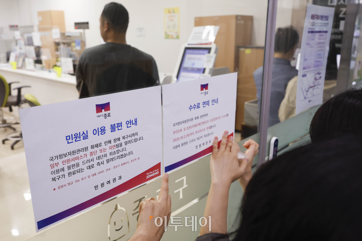 ▲국가정보자원관리원(국정자원) 대전 본원 화재로 전산망 마비 사태가 나흘째 이어지는 가운데 29일 서울 종로구 종로구청에서 직원들이 민원실 입구에 주민등록 등·초본과 인감증명서의 수수료 면제 안내문을 붙이고 있다. 조현호 기자 hyunho@