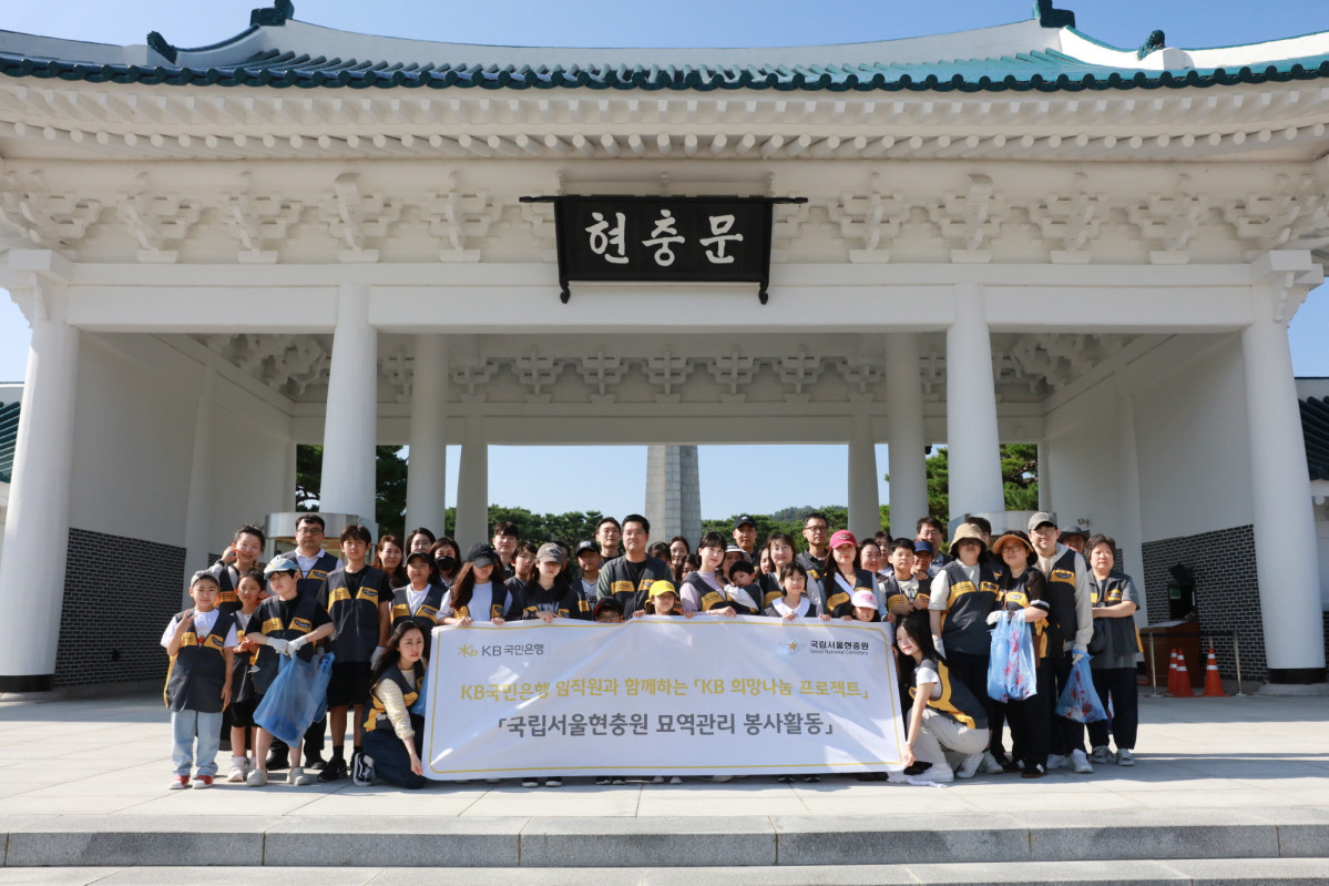 ▲KB국민은행 임직원과 가족들이 27일 서울 동작구 서울현충원에서 열린 묘역관리 봉사활동을 마친 후 기념촬영을 하고 있다. (사진제공=KB국민은행)