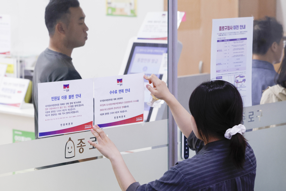 ▲국가정보자원관리원(국정자원) 대전 본원 화재로 전산망 마비 사태가 나흘째 이어지는 가운데 29일 서울 종로구 종로구청에서 직원들이 민원실 입구에 주민등록 등·초본과 인감증명서의 수수료 면제 안내문을 붙이고 있다. 조현호 기자 hyunho@(이투데이DB)