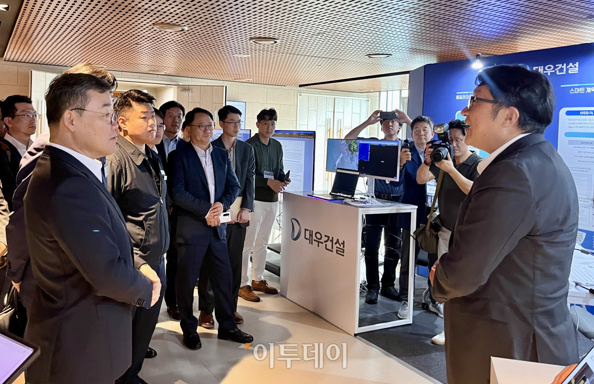 ▲김보현 대우건설 사장(왼쪽)이 30일 대우건설 본사에서 열린 '스마트건설 포럼'에 참석해 협력사들의 드론, 로보틱스 등 관련 전시부스를 둘러보고 관계자 설명을 듣고 있다.  (정유정 기자)