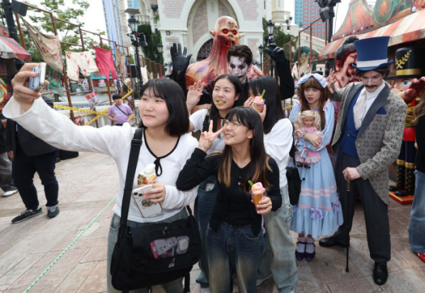 ▲25일 서울 송파구 롯데월드를 찾은 학생들이 가을 시즌 축제 ‘스트리트 호러쇼 : 더 마리오네트’를 선보이는 연기자들과 기념촬영을 하고 있다. 신태현 기자 holjjak@