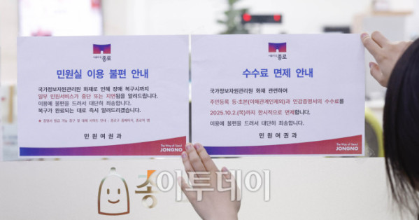 ▲국가정보자원관리원(국정자원) 대전 본원 화재로 전산망 마비 사태가 나흘째 이어지는 가운데 29일 서울 종로구 종로구청에서 직원들이 민원실 입구에 주민등록 등·초본과 인감증명서의 수수료 면제 안내문을 붙이고 있다. 조현호 기자 hyunho@