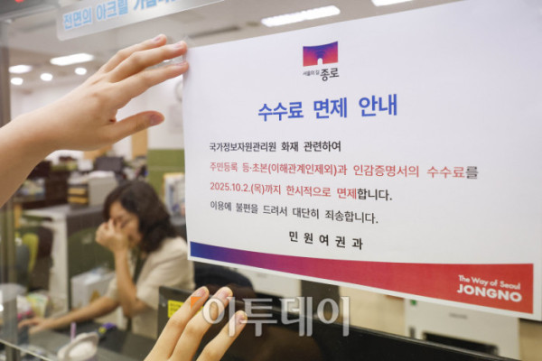 ▲국가정보자원관리원(국정자원) 대전 본원 화재로 전산망 마비 사태가 나흘째 이어지는 가운데 29일 서울 종로구 종로구청에서 직원이 민원대에 주민등록 등·초본과 인감증명서의 수수료 면제 안내문을 붙이고 있다. 조현호 기자 hyunho@