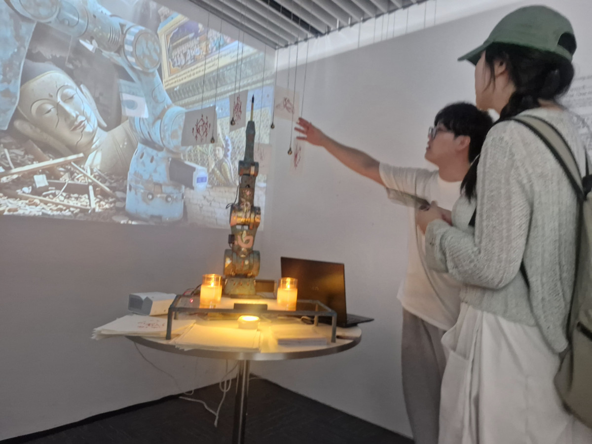 ▲국민대 AI디자인학과 제1회 졸업전시회에서 박승준(4학년)씨가 자신의 졸업 작품에 대해 다른 대학 학생에게 설명하고 있다. (손현경 기자)